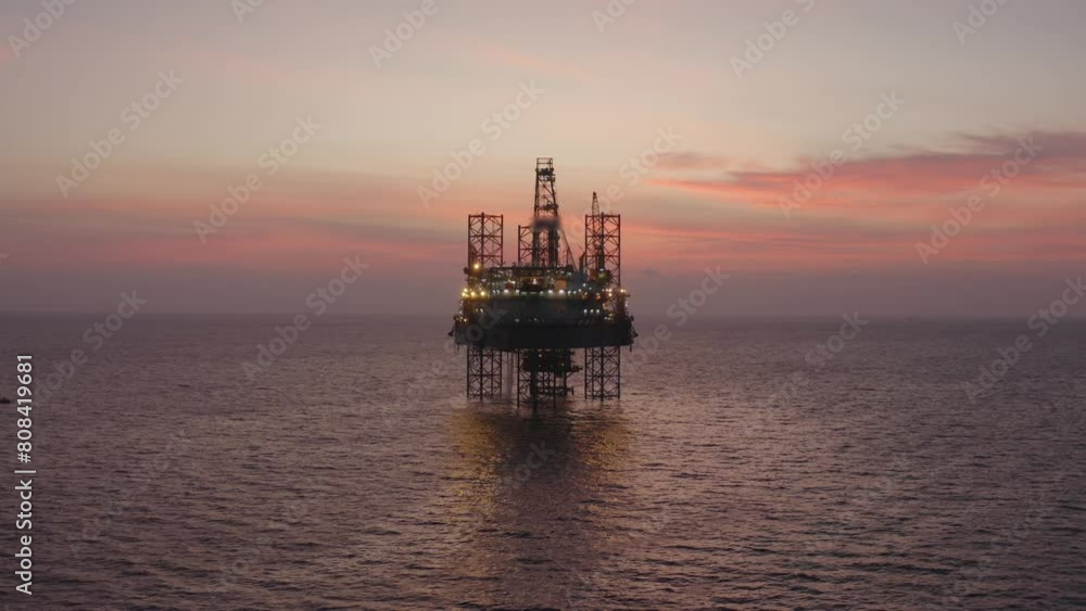 Aerial view of silhouette offshore jack up drilling rig during sunset - oil and gas industry Aerial view of silhouette offshore jack up drilling rig during sunset - oil and gas industry
