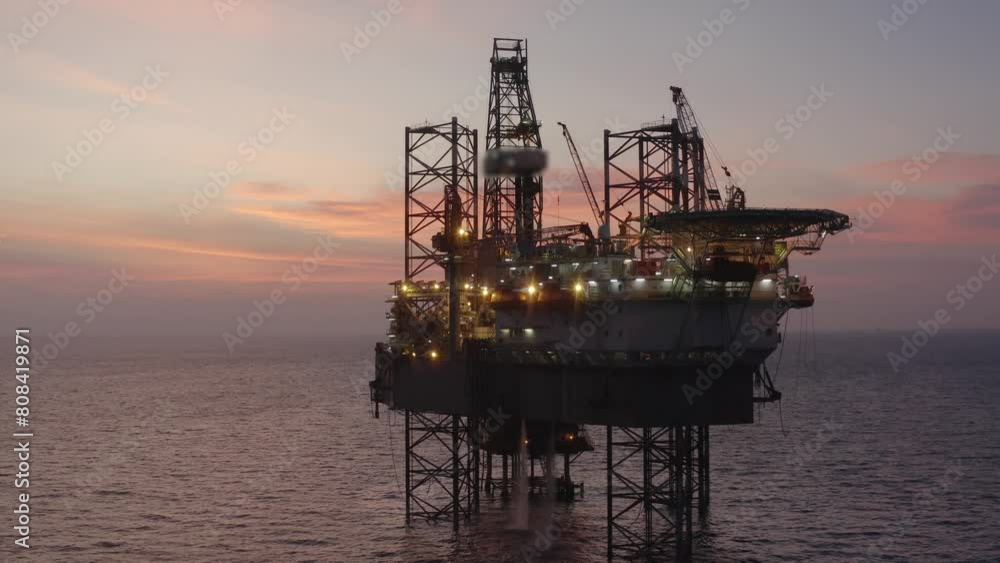 Aerial view of silhouette offshore jack up drilling rig during sunset - oil and gas industry Aerial view of silhouette offshore jack up drilling rig during sunset - oil and gas industry