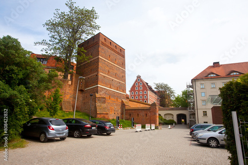 Krzywa wieża oraz zabytkowy spichrz z  XVIII wieku, którego opaski okienne przypominać mają worki ze zbożem, Toruń, Polska