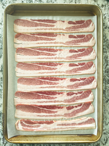 Raw Bacon Strips Ready for Cooking on a Baking Tray