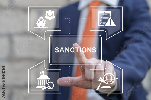 Politician or business man working on virtual touch screen presses word: SANCTIONS. World economic sanctions. Sanctions force country to obey international law by limit or stop trading concept.