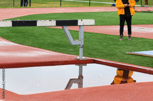 Reflection in the water of a track steeplechase water pit