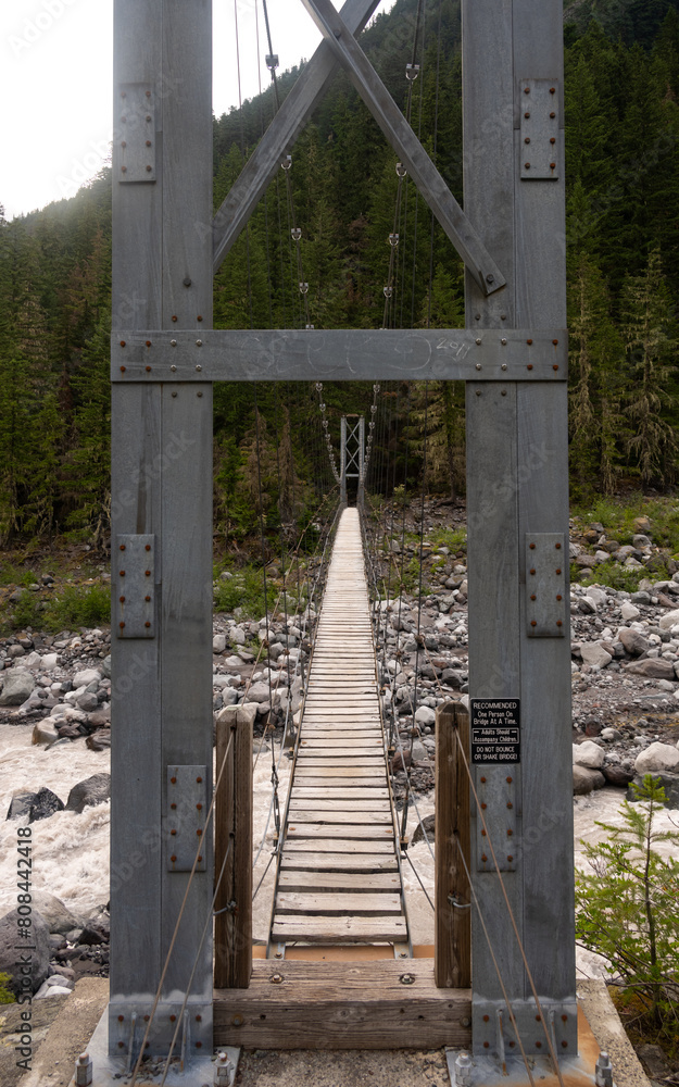 Metal Tower Frames the Wooden Deck Of The Carbon River Suspension Bridge Metal Tower Frames the Wooden Deck Of The Carbon River Suspension Bridge