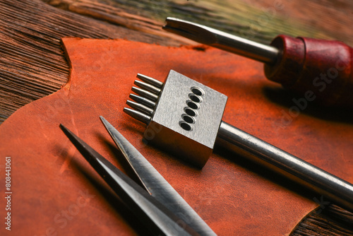 Leather craft work tools and leather on the tanner workbench concept background.