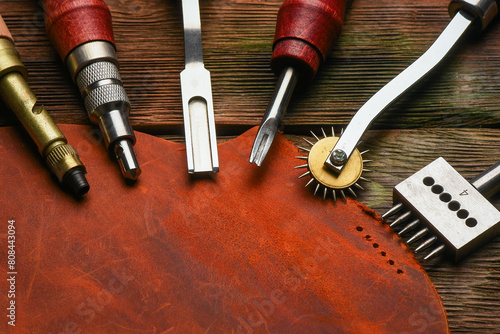 Leather craft work tools and leather on the tanner workbench concept background.