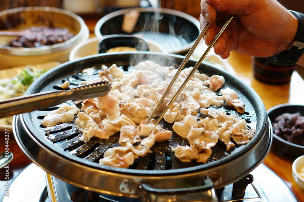 대패 삼겹살을 불판 위에서 구워서 먹는 모습 대패 삼겹살을 불판 위에서 구워서 먹는 모습