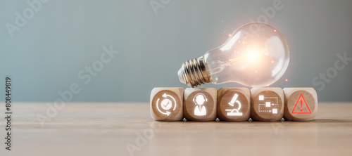 Incident management concept, Light bulb and wooden block on desk with incident management icon on virtual screen.