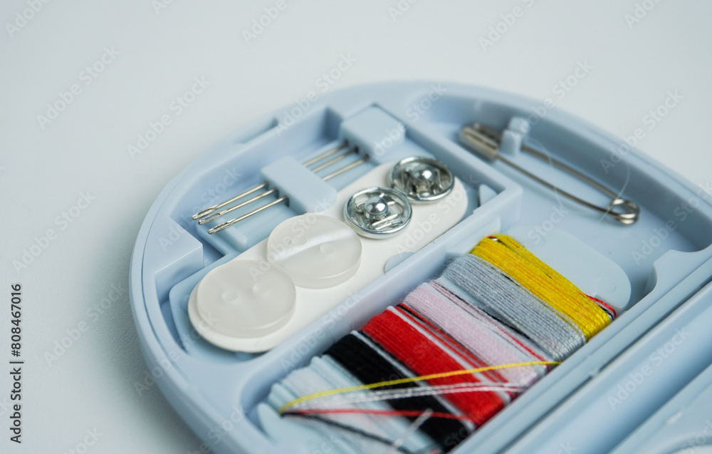 Compact travel small sized tailoring or stitching tools equipment in plastic blue container storage. Object photography isolated on white background. Compact travel small sized tailoring or stitching tools equipment in plastic blue container storage. Object photography isolated on white background.