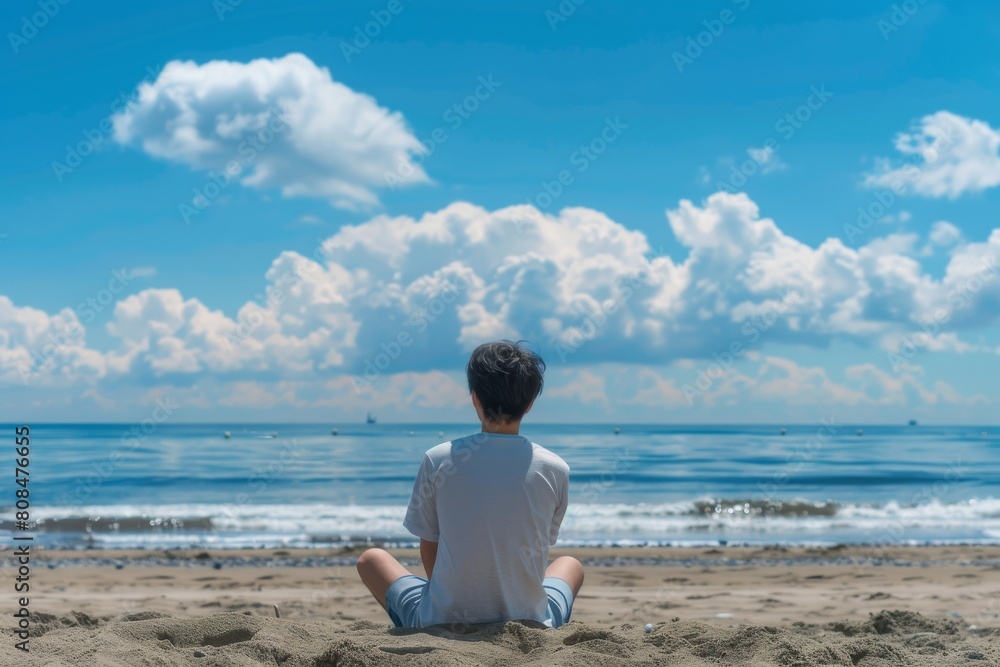 海を見ている日本人男性の後ろ姿（ビーチ・青空・旅行・休暇）
