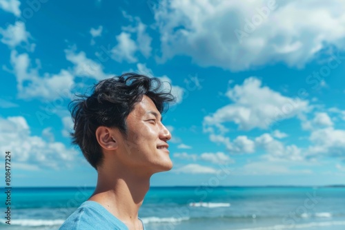 海を見ている日本人男性の横顔（ビーチ・青空・旅行・休暇）