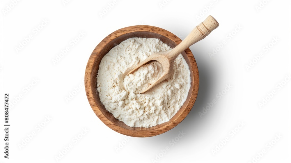 White flour is in a wooden bowl with a spoon on a white background. White flour is in a wooden bowl with a spoon on a white background.