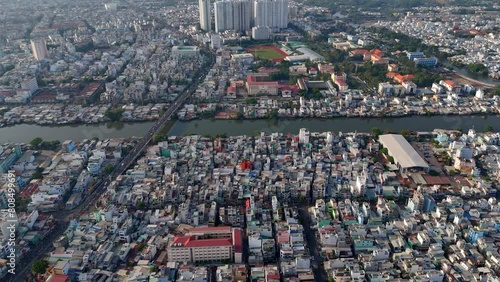 Attraction of big Asia city from aerial view at evening, crowd of vechicle as motorbike, motorcycle traffic on urban road riverside, residence near river, Ho Chi Minh city, Vietnam photo