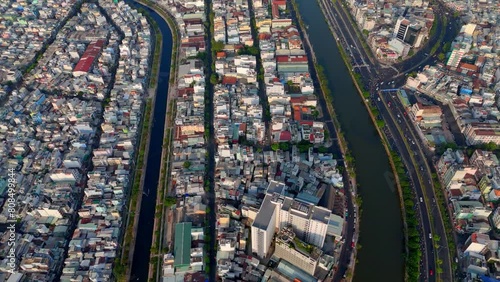 Attraction of big Asia city from aerial view at evening, crowd of vechicle as motorbike, motorcycle traffic on urban road riverside, residence near river, Ho Chi Minh city, Vietnam photo