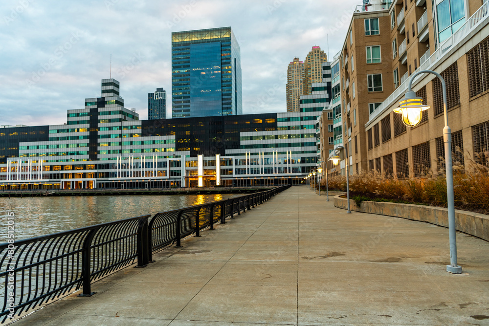 Path way in the street with urban architecture. Urban street promenade in city with modern architecture and lamp. Street lamp on waterfront city promenade. City downtown cityscape Path way in the street with urban architecture. Urban street promenade in city with modern architecture and lamp. Street lamp on waterfront city promenade. City downtown cityscape