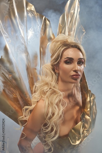 Portrait of mysterious woman in golden armor in studio