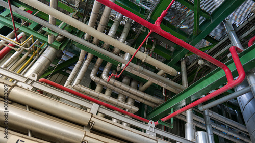 A view of a large industrial building with pipes and red and yellow pipes photo