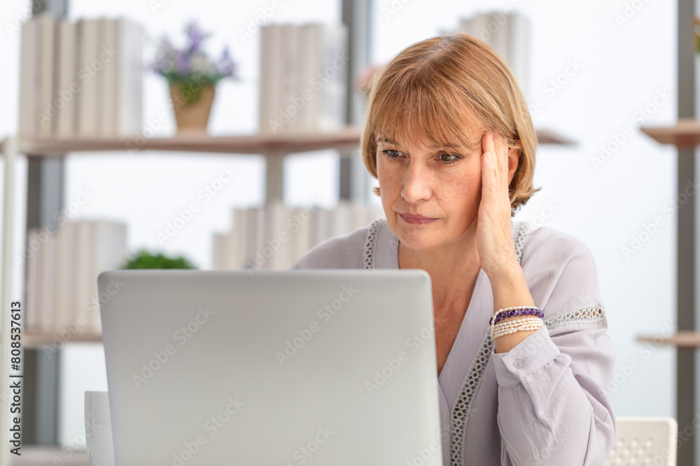 Worried caucasian woman using laptop to check their bills at home Worried caucasian woman using laptop to check their bills at home
