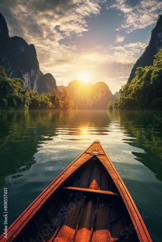 A boat is on a lake with mountains in the background. The sun is setting, casting a warm glow on the water