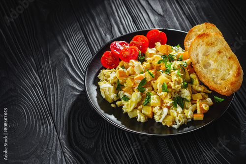 tasty scrambled eggs with zucchini on a black rustic rustic background