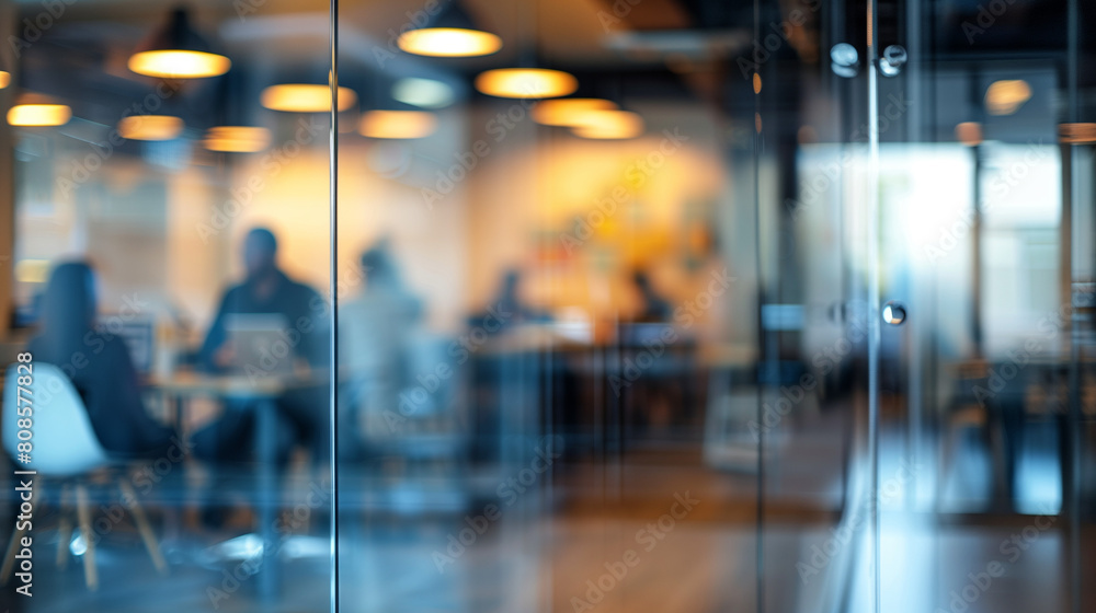 Blurred office with people working behind glass wall Blurred office with people working behind glass wall