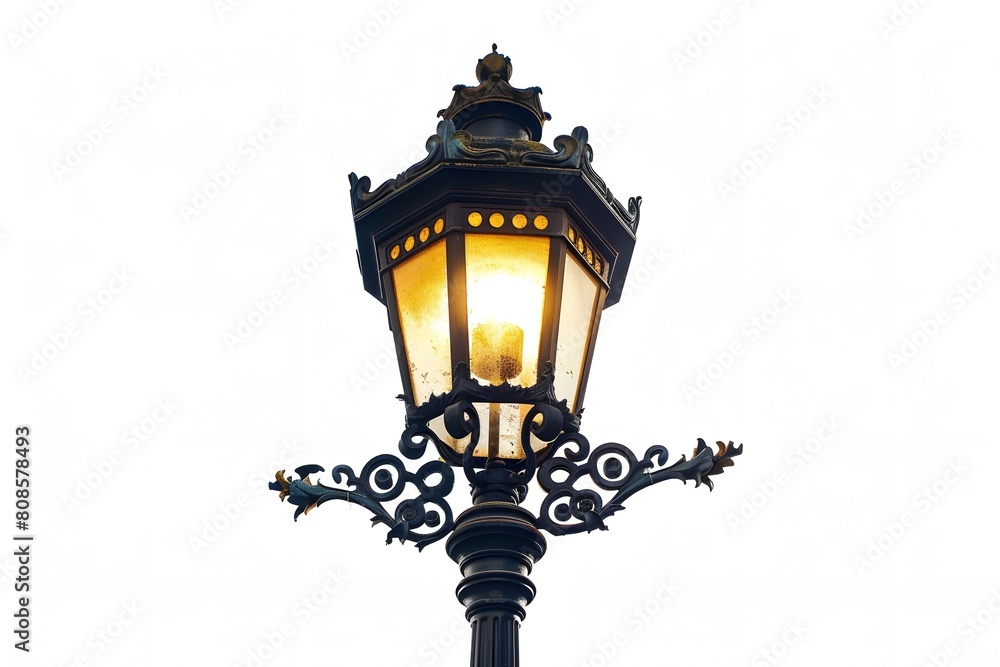 A close-up of an ornate vintage street lamp glowing warmly against a clear sky, capturing a nostalgic and charming urban atmosphere.