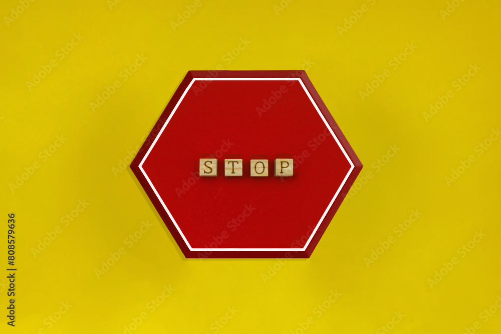 Φωτογραφία 黄色い背景のSTOPの英語ブロックを使った六角形の赤い標識