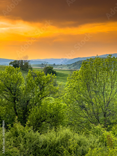 Landscapes of Transylvania. Vertical photo with an amazing sunset over the hills and villages of Transylvania in Harghita county. Travel to Romania country side.