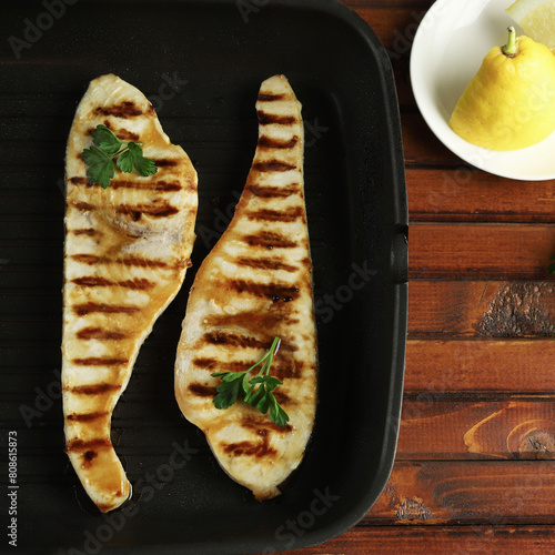 Bistecca di pesce spada alla griglia con limone su tavolo di legno. Concetto di cibo sano. Frutti di mare. Direttamente sopra.