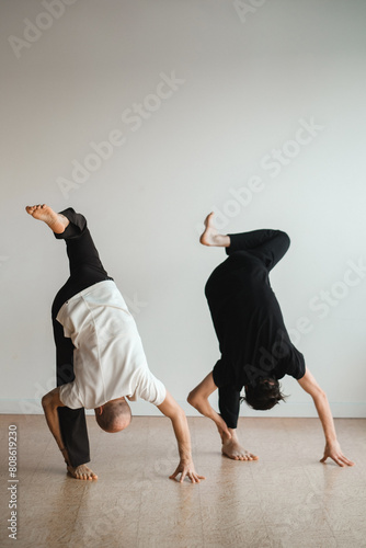 two young athletes practice yoga in the gym. Joint training, indoors, studio. The concept of a healthy lifestyle