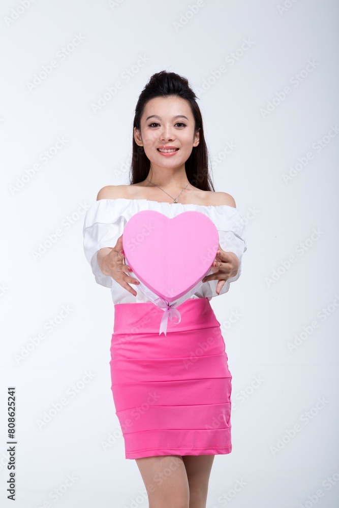 Shed on fashionable young woman holding a gift box Shed on fashionable young woman holding a gift box
