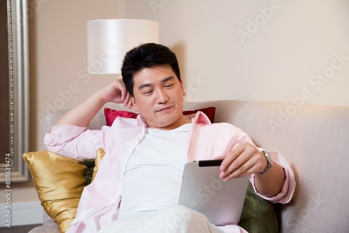 Middle-aged man reading a book in the living room