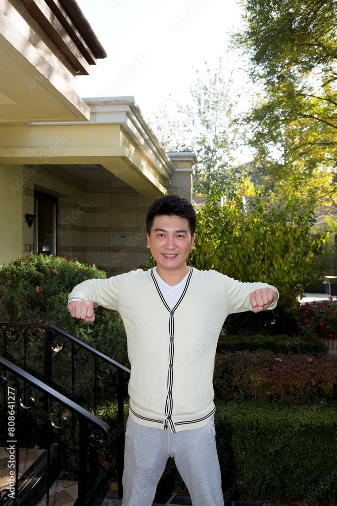 Fototapeta premium Middle-aged man doing morning exercises in the yard