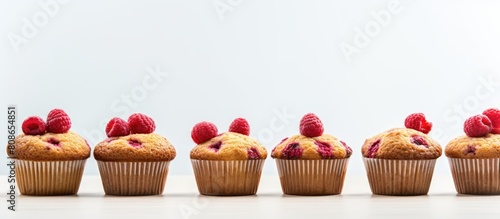 Copy space image featuring a grid of delectable raspberry muffins against a light background