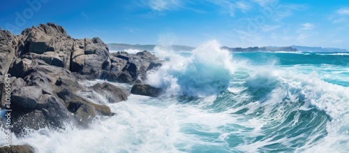 A scenic view of powerful ocean waves crashing against the rocky coastline creates an ideal backdrop for a vacation Perfect for wallpapers or copy space images
