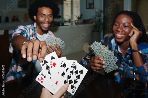 Friends enjoying playing cards at home Friday night photo