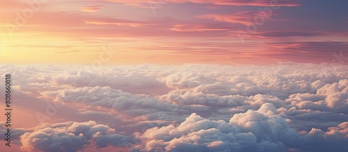 The view from the airplane window showcases a red sky at a high altitude with fluffy dense puffs of white clouds reflecting the sunset Although the image is hazy and noisy there is still ample copy s photo