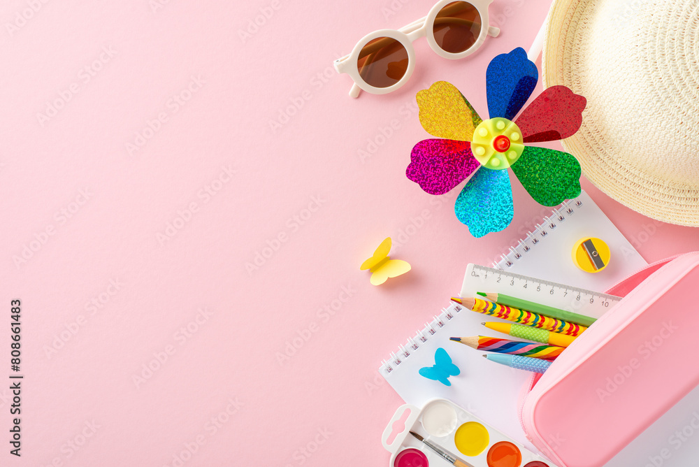 Vibrant children's summer educational tools including a colorful pinwheel, school supplies, and a straw hat spread over a pink background, symbolizing fun learning
