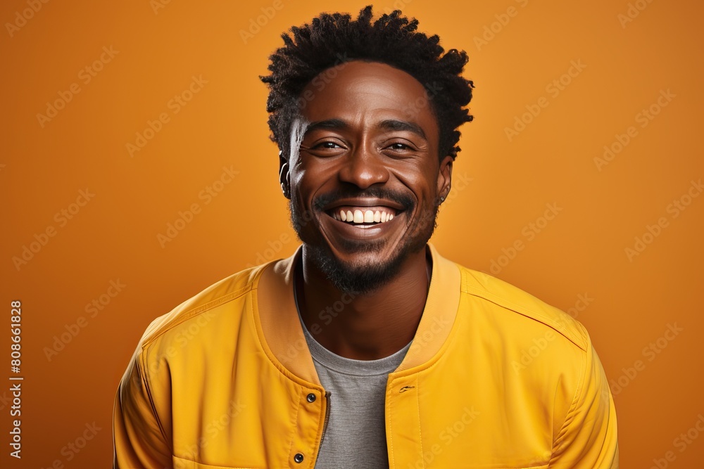 Smiling black man in a yellow jacket on a yellow background. Smiling black man in a yellow jacket on a yellow background.