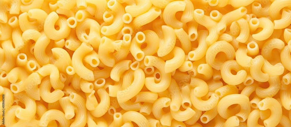 Top view image of raw macaroni surrounded by ingredients for making macaroni and cheese A copy space is available at the center of the image Top view image of raw macaroni surrounded by ingredients for making macaroni and cheese A copy space is available at the center of the image
