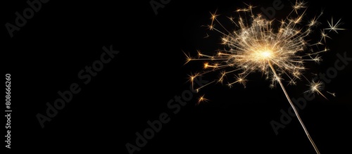 A sparkler illuminating on a black background creating a captivating copy space image