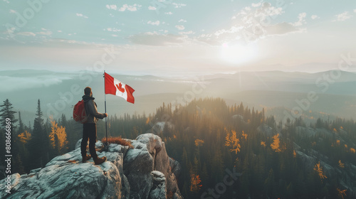 A man with a Canadian flag stands on a mountain cliff against a background of a beautiful forest. Canada day concept photo