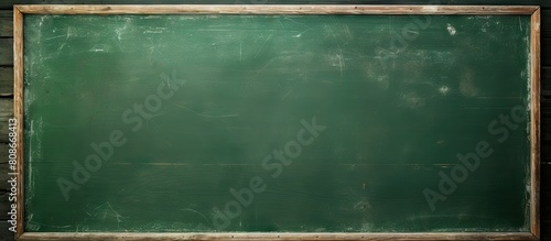 A green chalkboard with a textured surface serves as a school board display The chalk traces have been erased leaving a copy space for adding text or graphic design This backdrop embodies educational photo