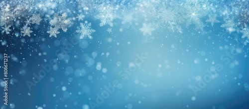 Copy space image of a blurred winter blue background with snowflakes serving as a template for a banner