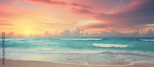 A vintage style color filtered copy space image of a tropical beach where soft sand meets the sea and a picturesque sunset sky with clouds create an abstract background This evokes a sense of freedom