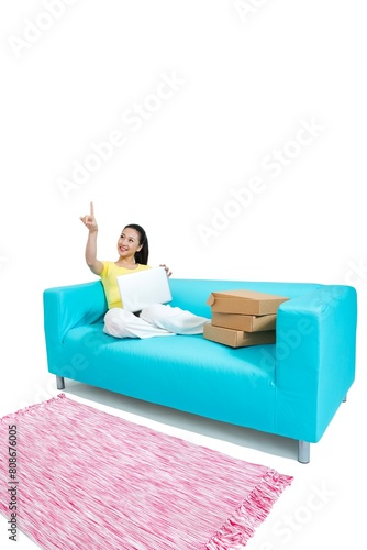 Shed young woman sitting on a couch surfing the Internet shopping photo