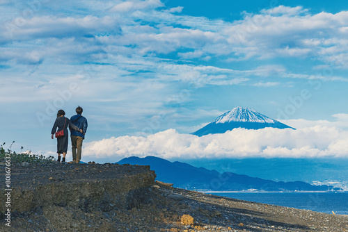 海辺から富士山を望むカップル