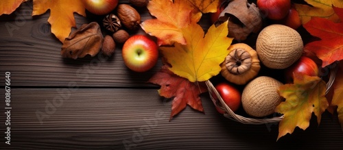 Copy space image of walnuts ripe apples pumpkins acorns and autumn leaves arranged in a basket viewed from above