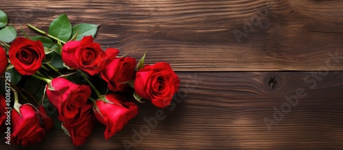 A romantic Valentine s Day setting with a copy space image displaying beautiful red roses arranged on a rustic wooden table
