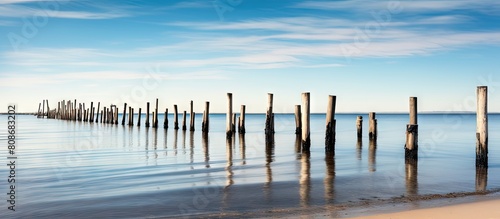 Tranquil seascape over old piers in Hyannis on Cape Cod with a white sand beach docks pilings and a maritime village in the background. Copy space image. Place for adding text and design photo