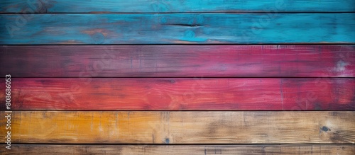 A textured background of an old wooden board with multicolor hues ideal for use as a copy space image